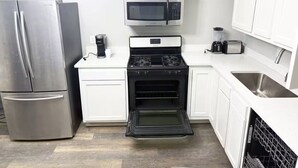 Een koffiezetapparaat/waterkoker, een koelkast, een magnetron, een oven