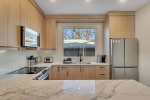 Fridge, microwave, oven, stovetop - Modern 2BR/2BA Suite: 5-Min Walk to LRT & Golf with Garage Parking (Calgary)