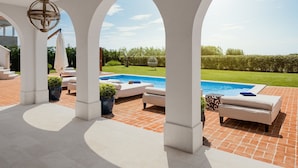 A covered outdoor area with a pool, lounge chairs, and a pergola structure. - Villa Palazzo di Ivana with Pool (Vabriga)