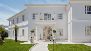 A large, white, two-story building with a central entrance, a balcony with white railings, and a well-maintained lawn. - Villa Palazzo di Ivana with Pool (Vabriga)
