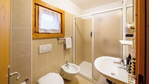 A bathroom with a toilet, bidet, and sink. - Hotel Ambassador Bormio (Bormio)