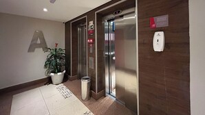 An elevator with a digital display, emergency exit sign, and a "CLEAN" sign on the wall. - Flat com Piscina Academia e Sauna em Guas Claras (Águas Claras)