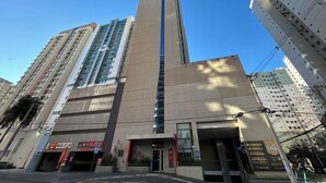 A modern building with a central vertical feature, possibly a lobby or atrium, and multiple floors with balconies. - Flat com Piscina Academia e Sauna em Guas Claras (Águas Claras)