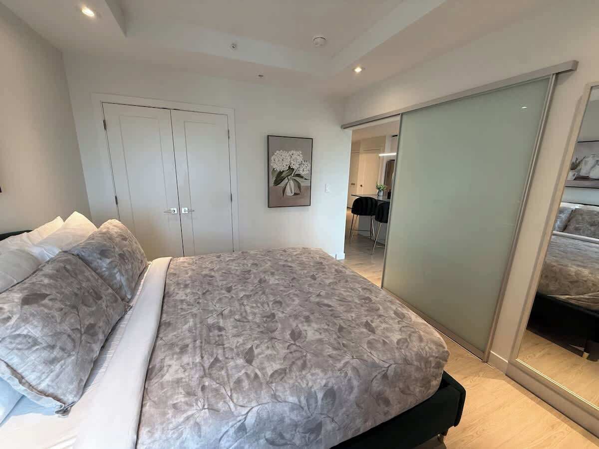 Ein Schlafzimmer mit einem großen Bett, einem Kleiderschrank und einer Tür zu einem Badezimmer.