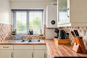 A kitchen with a double sink, a coffee maker, and a knife block. - Cozy & Self Contained The Garden Annex 306 (Salisbury)