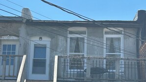 A two-story building with a balcony, a garage, and a bicycle.