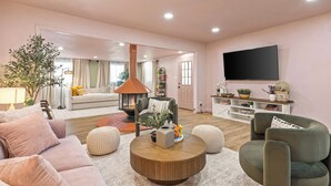 Una sala de estar moderna con chimenea, asientos cómodos, televisor de pantalla plana y un ambiente acogedor.