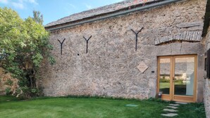 Un edificio de piedra con una puerta de madera y un cartel que dice "GITE TILLEUL".