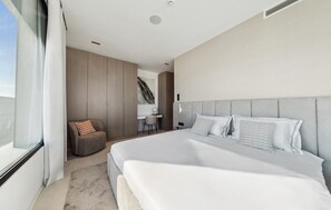 Une chambre à coucher moderne avec un grand lit, un bureau et une chaise.
