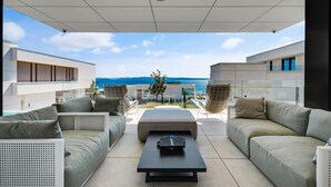 A modern outdoor living area with a sofa set, a coffee table, and a view of the sea. - Beautiful home in Ugljan (Ugljan)
