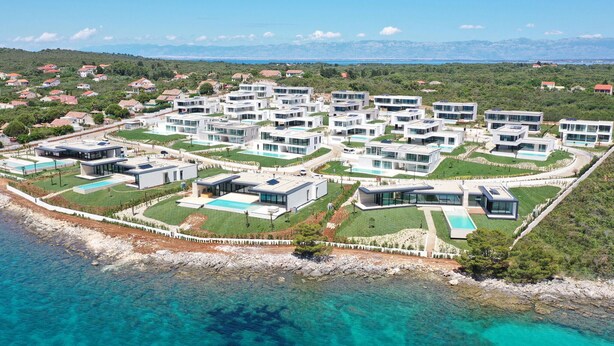 An aerial view of a coastal residential area with modern houses, clear blue waters, and a hilly landscape in the background. - Amazing home in Ugljan with private swimming pool, can be inside or outside (Ugljan)
