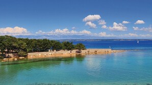 A coastal landscape with clear turquoise waters, a rocky shoreline, and a backdrop of mountains and a clear sky. - Awesome home in Ugljan with private swimming pool, can be inside or outside (Ugljan)