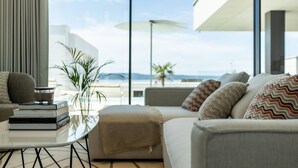 Un salon moderne avec un canapé, une table basse et une vue sur la plage.