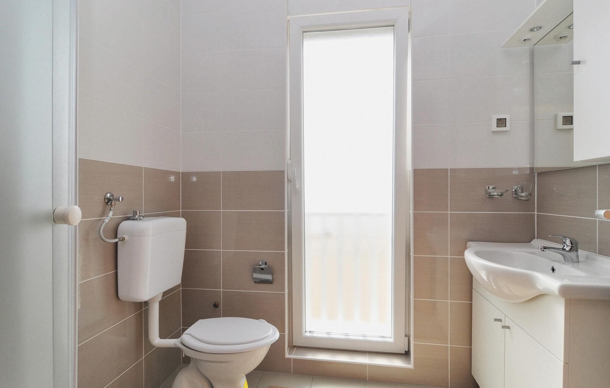 Un baño con inodoro, bidé y lavamanos.