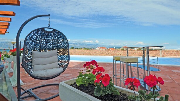 A hanging chair by a pool with a view of mountains. - Lovely apartment in Nin with WiFi (Nin)