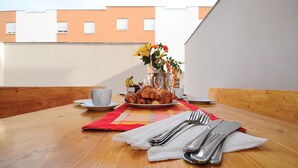 Una mesa de desayuno con croissants, una taza y un florero con flores.