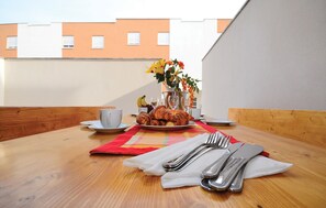 A breakfast table with croissants, a cup, and a vase with flowers. - Gorgeous apartment in Nin with swimming pool (Nin)