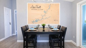 A dining area with a map of Lake Powell, Arizona and Utah, a chandelier, and a table set for two. - Large King Bedroom/55" TV/Big fenced yard w games/Dogs welcome/Boat parking (Page)