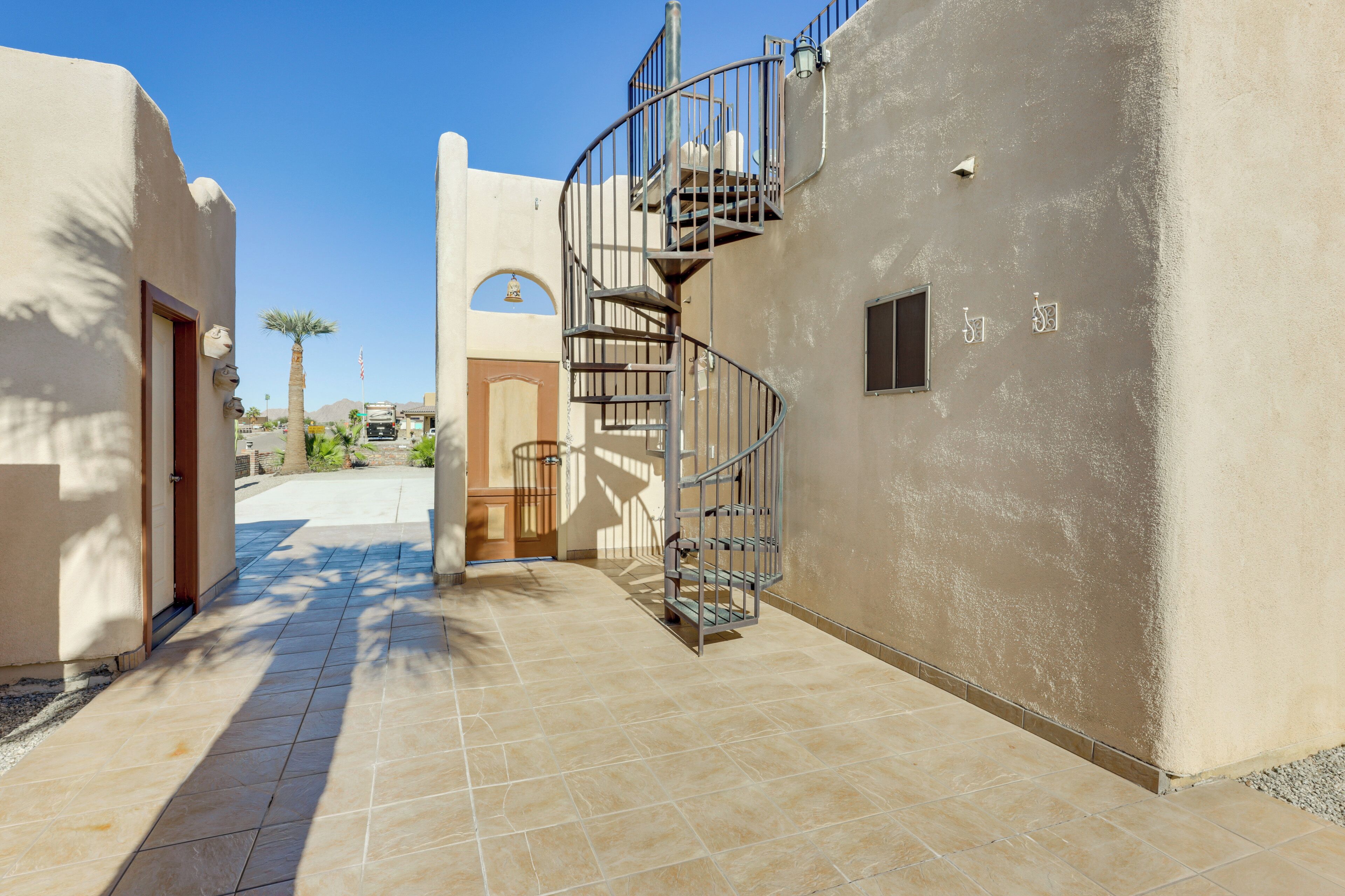A spiral staircase leading to an upper floor, a door, and a small window with bicycle symbols.