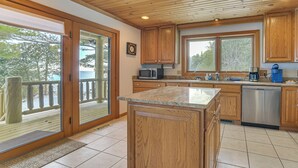 A kitchen with wooden cabinets, a microwave, a coffee maker, and a dishwasher. - On-Site Trails & Private Beach! Lake Huron Retreat (Harrisville)