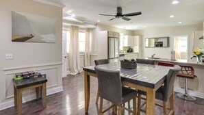 Un coin repas avec une table en marbre, des chaises en bois et une petite table d’appoint sur laquelle sont posées des boîtes.