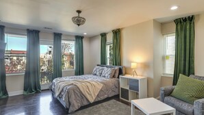 Une chambre à coucher avec un lit, une table de chevet, une lampe et une vue sur l’extérieur.