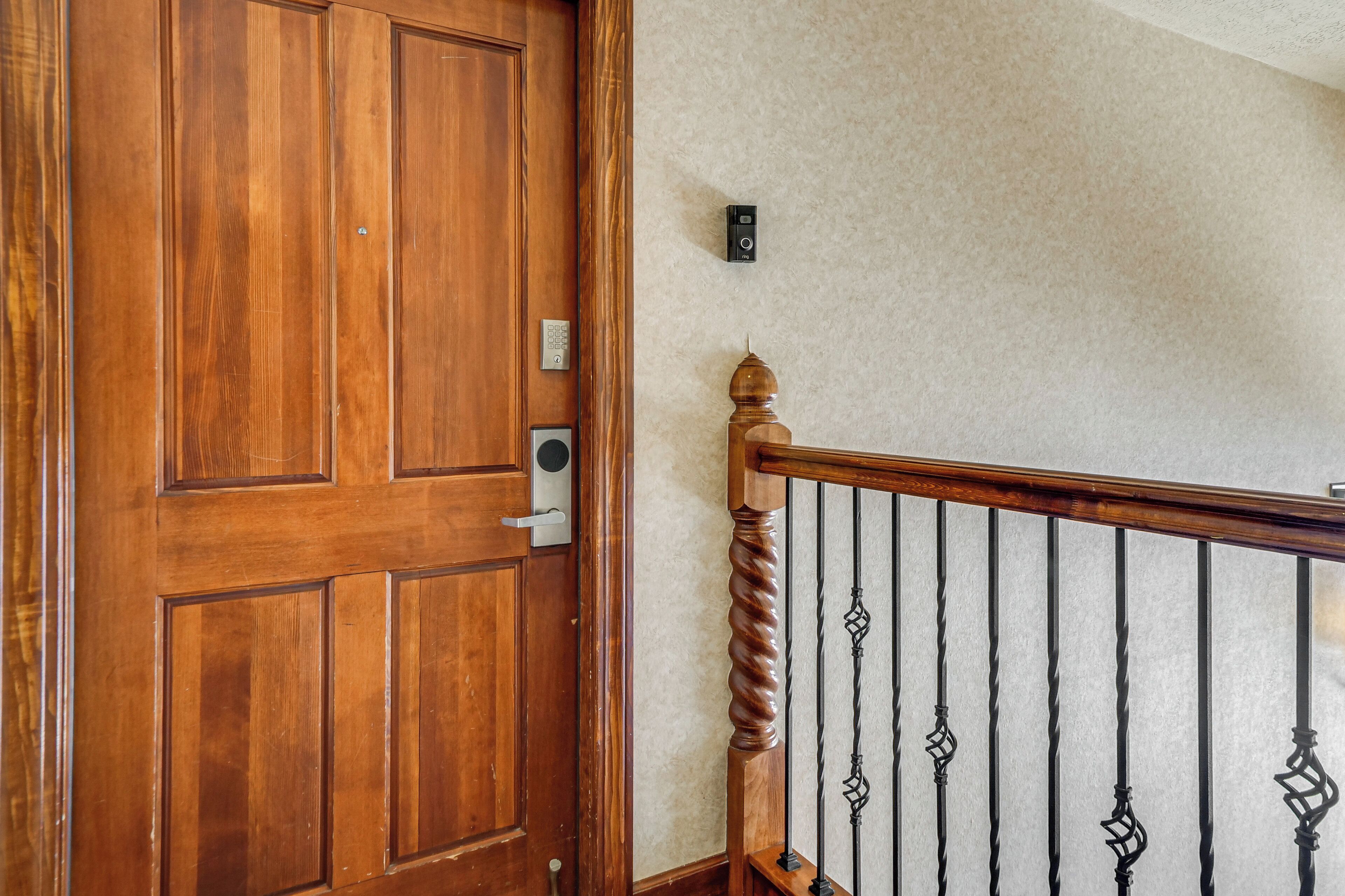 A wooden door with a keypad lock and a wall-mounted intercom.