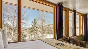 A hotel room with a large window, a bed, and a sofa. - Continental Divide Views: Lakefront Keystone Condo (Keystone)