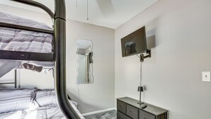 A bedroom with a bunk bed, a dresser, a mirror, and a TV mounted on the wall. - 12 Mi to Dtwn Savannah: Remodeled Family Getaway! (Pooler)