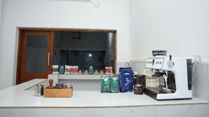 Una encimera de cocina con una cafetera, granos de café y bolsas de café Starbucks.