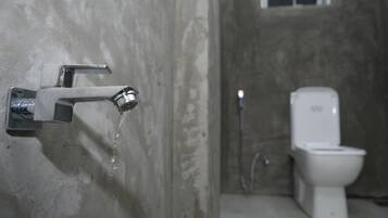 Un baño con inodoro blanco y ducha.