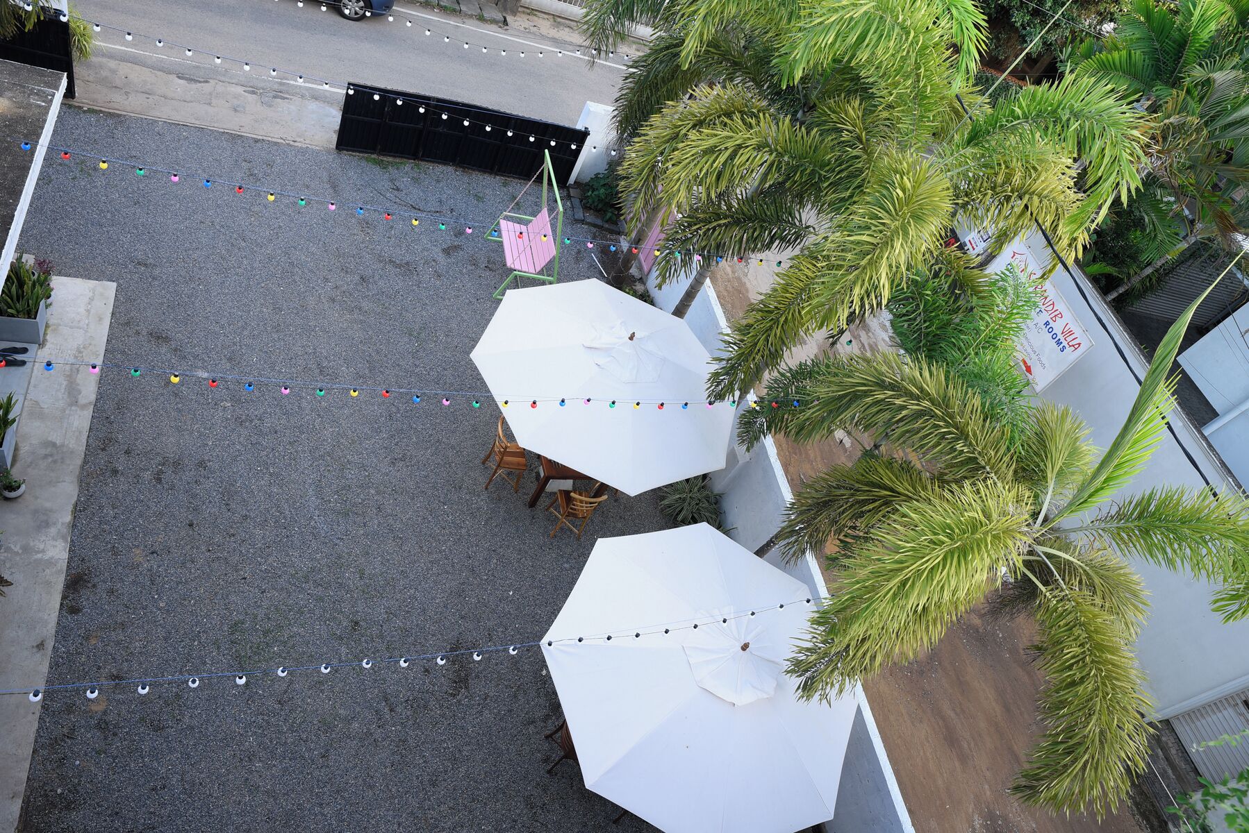 An outdoor seating area with white umbrellas and string lights.