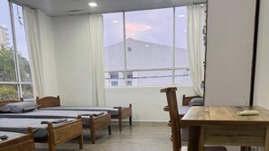 Una habitación con cuatro camas de madera, un escritorio de madera y una silla.