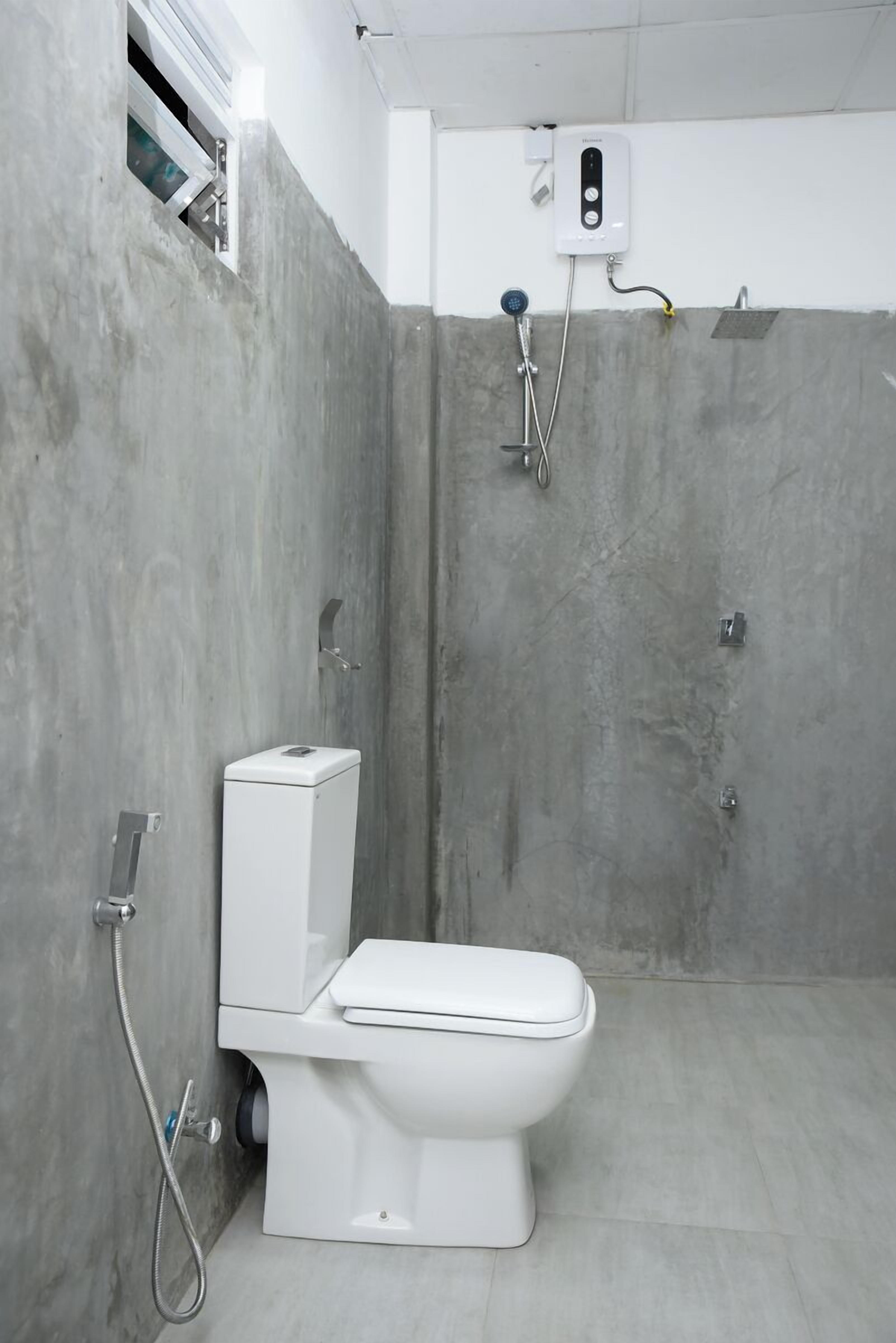 A modern bathroom with a toilet, shower, and a control panel on the wall.