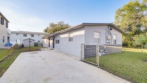 A single-story mobile home with a fenced yard, a concrete driveway, and a small garden area. - Walk to Shops, Dining & Casino: Dania Beach Home (Dania Beach)