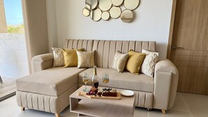 Een moderne woonkamer met een hoekbank, een houten salontafel en een decoratieve spiegelwand.