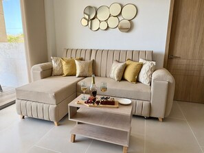 Ein modernes Wohnzimmer mit Ecksofa, Couchtisch aus Holz und einer Wand mit dekorativen Spiegeln.