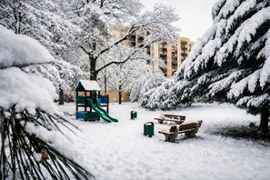 A snow-covered park with a playground, benches, and trees. - Superb 3-bedroom apartment in the heart of Mulhouse (Mulhouse)