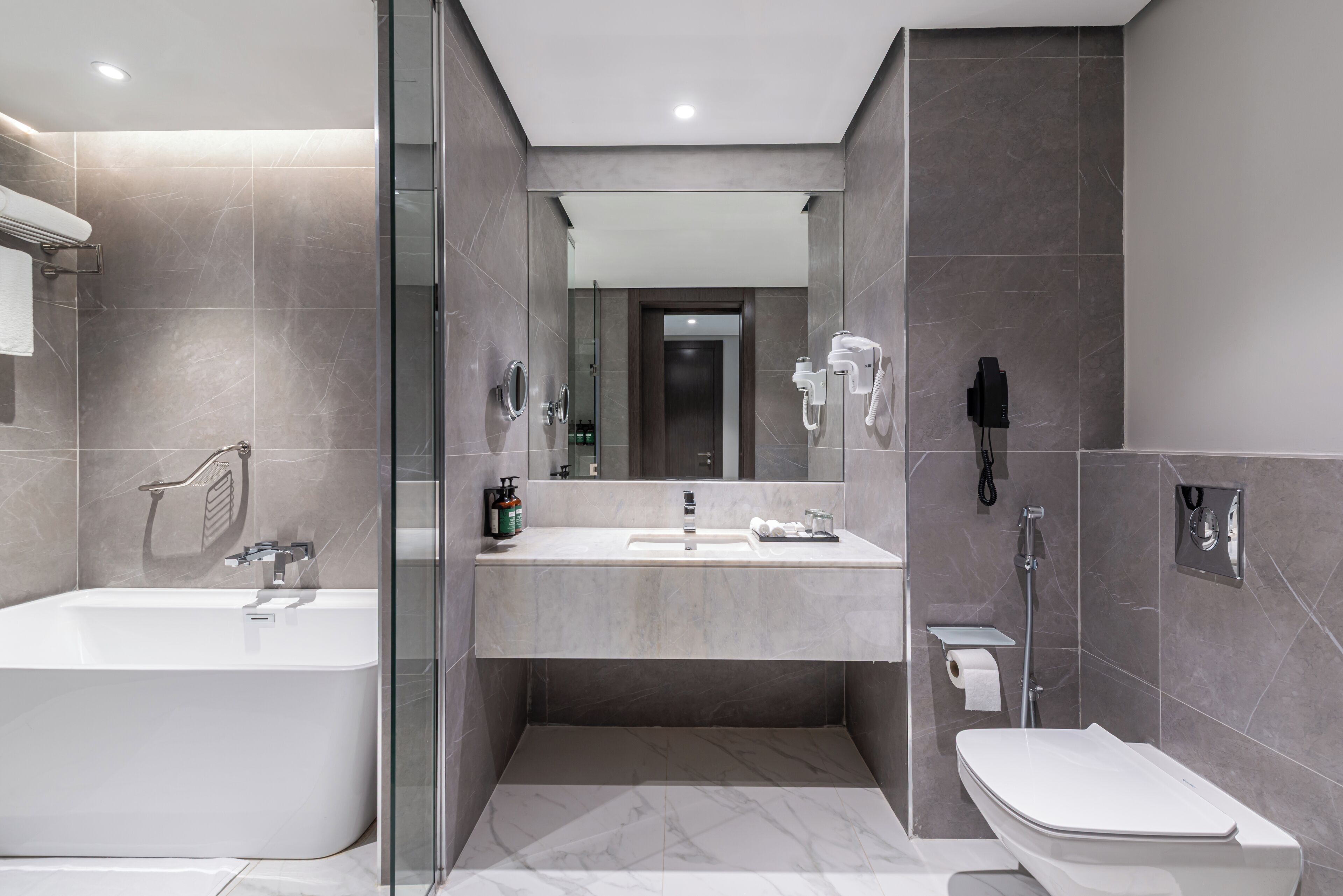 A modern bathroom with a bathtub, a sink, and a toilet.