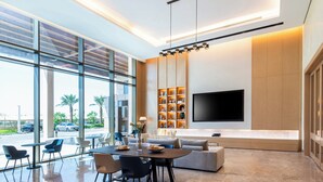 Ein modernes Interieur mit Essbereich, Sofa, Fernseher und Regalen.