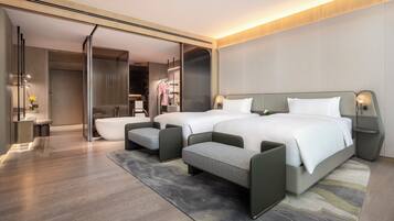 Une chambre d’hôtel moderne avec deux lits, un coin salon et une salle de bain.