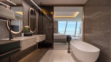 A modern bathroom with a freestanding bathtub, a large mirror, and a vanity with a marble countertop.