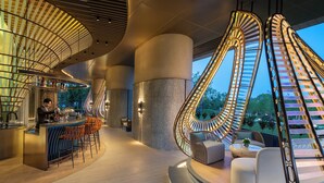 A modern interior with a bar area, seating, and a spiral staircase. - Intercontinental Huzhou Taihu South By Ihg (Huzhou)