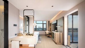 Un baño de hotel moderno con un espejo grande, un lavamanos y una ducha.