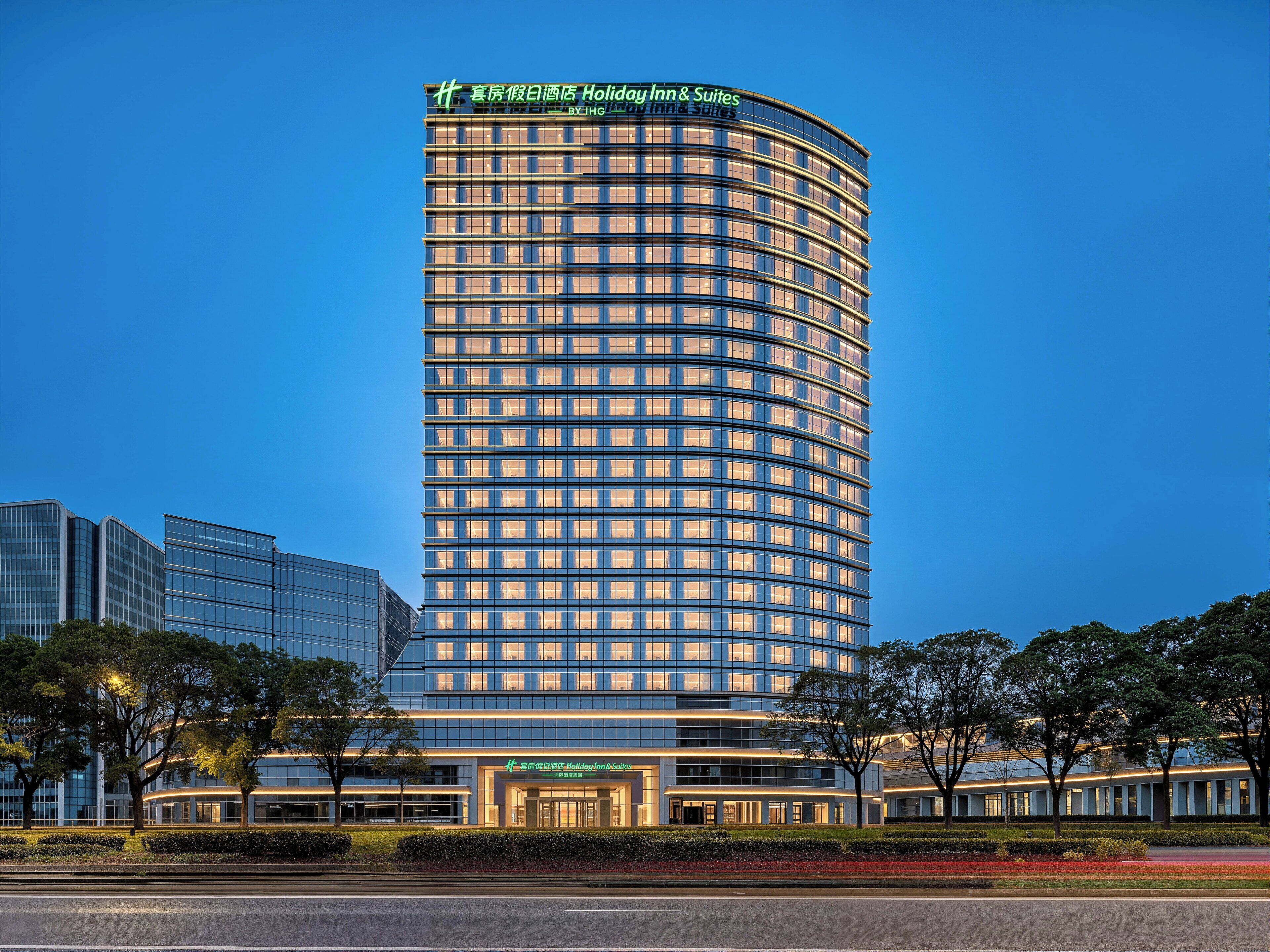 A high-rise hotel with a curved facade, multiple floors, and a prominent signage at the top.