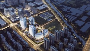 Vista aèria d'una zona urbana moderna amb edificis alts, carreteres i espais verds.