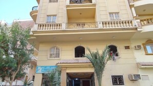 A multi-story building with a central entrance, balconies, and a ground-level shop. - Marvelous 2-bedroom apartment with AC in Red Sea Governorate (Red Sea Governorate)