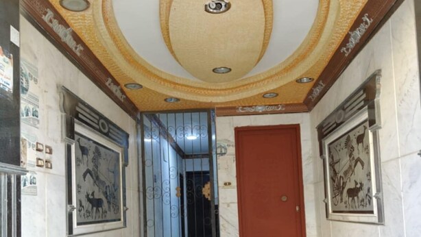 A hallway with a marble floor, a red door, and decorative ceiling with recessed lighting. - Marvelous 2-bedroom apartment with AC in Red Sea Governorate (Red Sea Governorate)