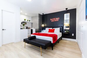 A modern bedroom with a bed, bedside tables, a desk, and a mirror. - Chic & Stylish Studio in Vibrant Miami (Miami)