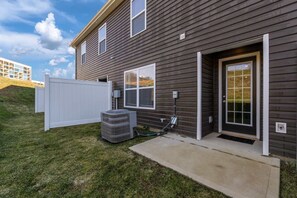 A modern two-story house with a dark siding exterior, a white front door, and a small front yard. - ‼️New 3BR Raceday Retreat - Steps from Speedway (Bristol)